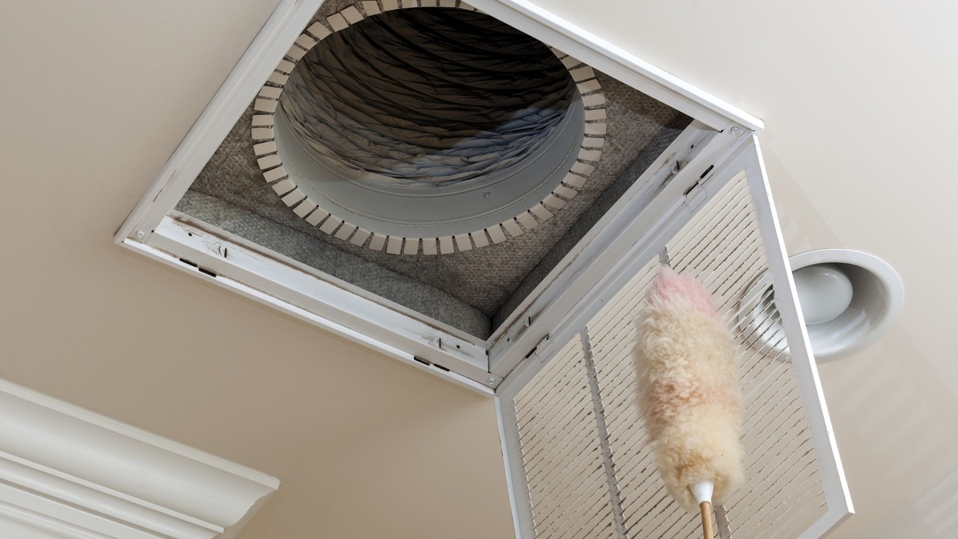 Ceiling vent with fluffy duster cleaning around air duct opening