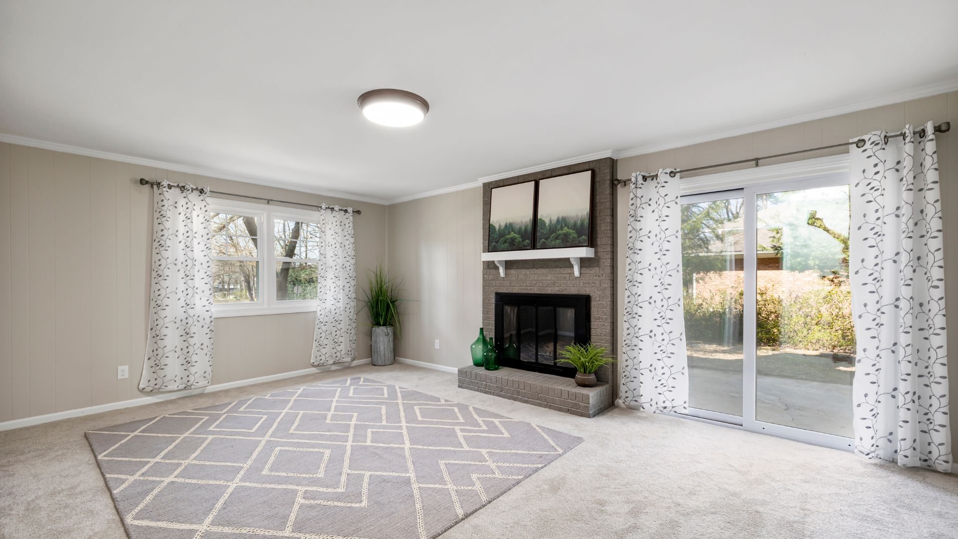 Bright living room with fireplace, geometric rug, and large windows